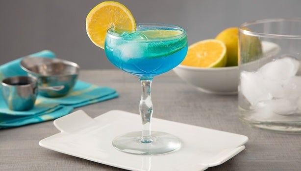 Imagem de um copo de drink lagoa azul com uma rodela de laranja.