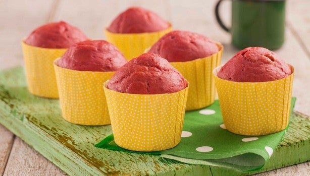 Muffin de beterraba em forminhas amarelas sobre uma tábua verde.