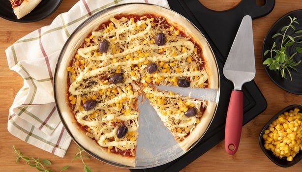 Imagem vista de cima de uma pizza de frango com catupiry e azeitonas.