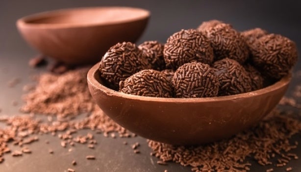 Ovo de chocolate aberto recheado com brigadeiros de chocolate com granulado.