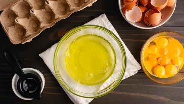 Albumina: o que é e qual a sua função no nosso corpo Texto alt: Claras e gemas de ovo separadas em tigelas sobre mesa de madeira, representando a albumina.