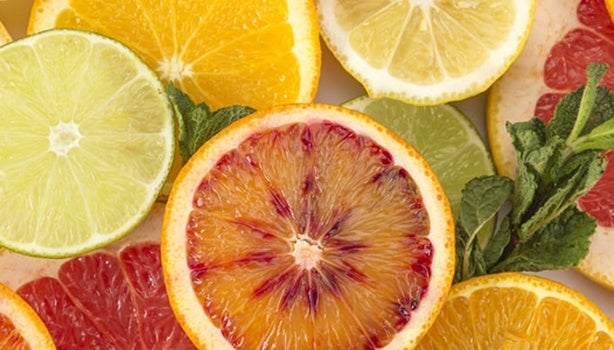 Frutas cítricas variadas cortadas ao meio, como o limão e a laranja. A imagem representa os alimentos ricos em citrato.