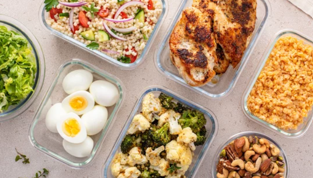 Marmitas com refeições saudáveis, incluindo legumes, ovos, frango grelhado, grãos e castanhas.