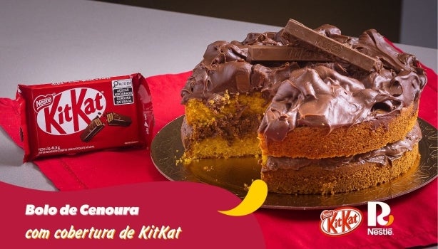 Como fazer esse Bolo de Cenoura com recheio e cobertura de KitKat®! Fotografia de um bolo de cenoura e logo de KitKat.