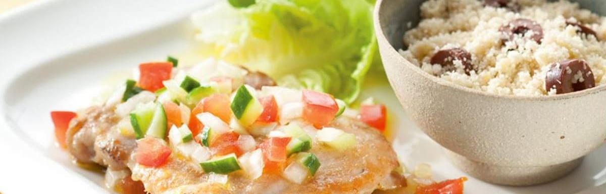 Vinagrete com salada em cima de um prato ao lado de uma tigela com farofa