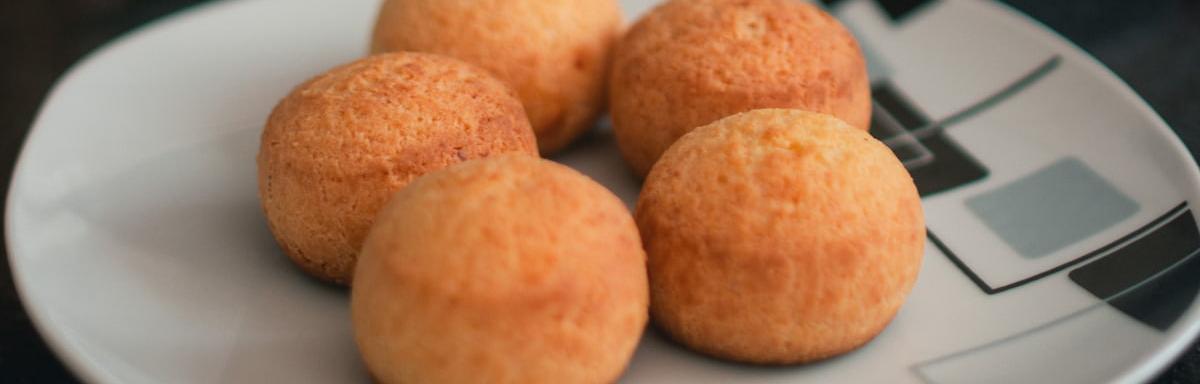 Pão de Queijo: 4 pães de queijo em cima de um prato