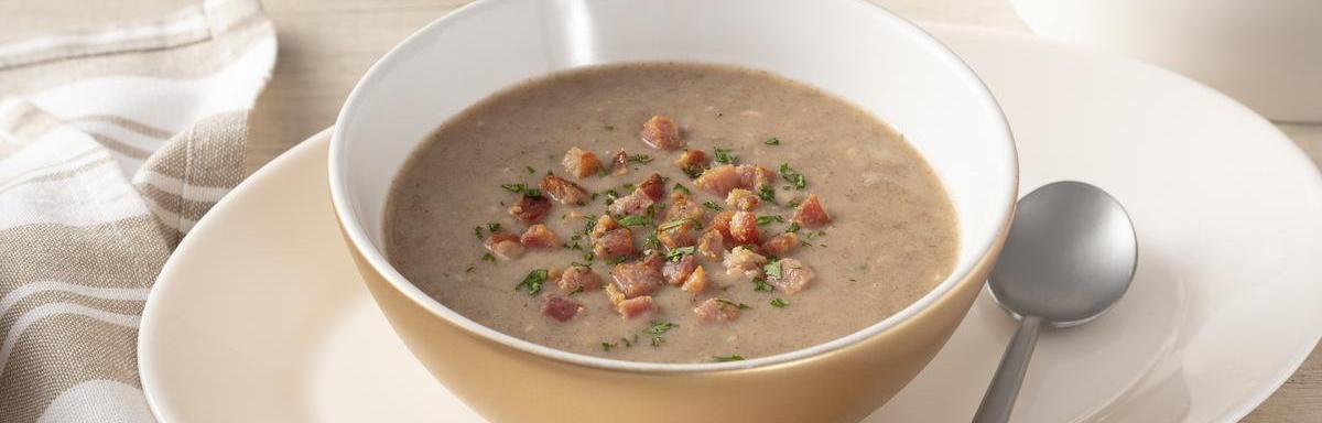 As melhores comidas de Inverno: Sopa de feijão na tigela em cima de um prato, ao lado uma colher