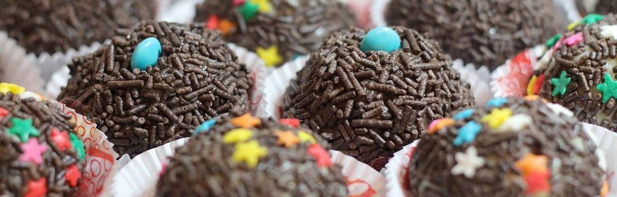 Docinhos Fáceis: Vários brigadeiros em forminhas de celofane, enfeitados com confete