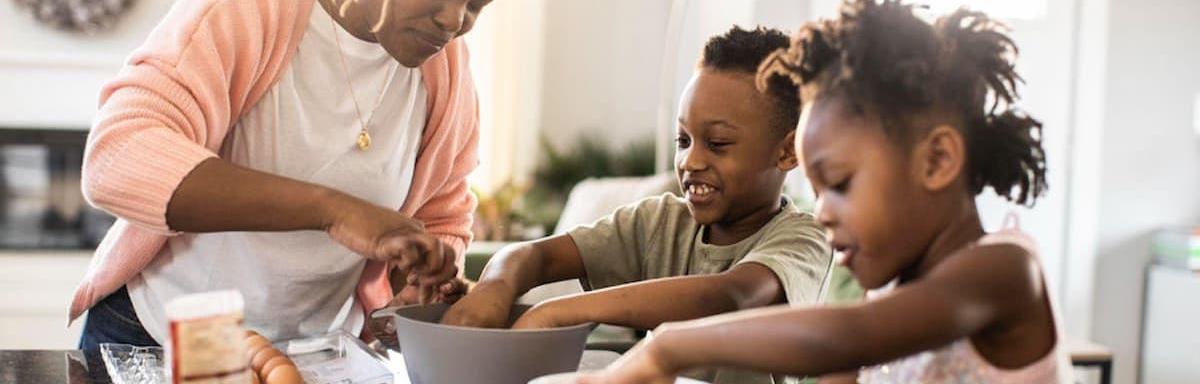 Mês das Crianças: mãe cozinhando com os filhos