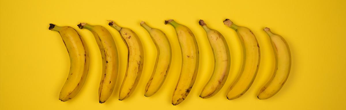 Bananas enfileiradas em cima de um pano amarelo 