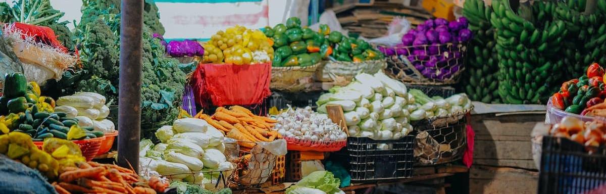 Várias cestas com vegetais dentro delas em uma banca