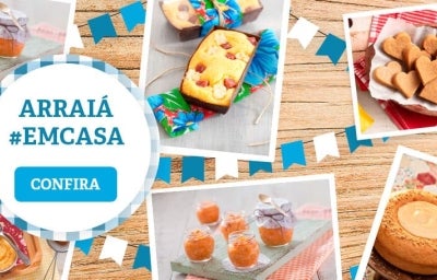 Imagem com comidas típicas de Festa Junina. À esquerda, há um banner com a mensagem "arraiá em casa".