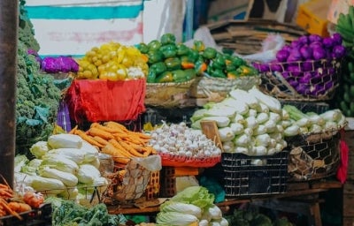 Várias cestas com vegetais dentro delas em uma banca