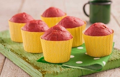 Muffin de beterraba em forminhas amarelas sobre uma tábua verde.