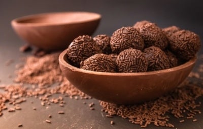 Ovo de chocolate aberto recheado com brigadeiros de chocolate com granulado.