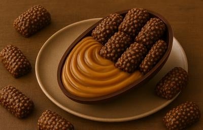 Meio ovo de Páscoa recheado com doce de leite e decorado com chocolates crocantes Chokito sobre prato marrom.
