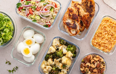 Quantas refeições fazer por dia, afinal? Marmitas com refeições saudáveis, incluindo legumes, ovos, frango grelhado, grãos e castanhas.