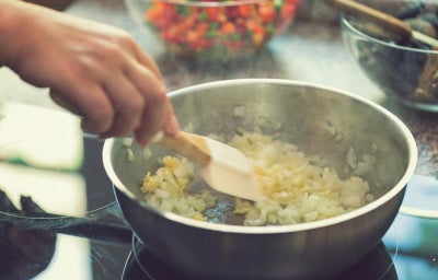 Cebola: uma pessoa cozinhando cebola na panela