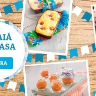 Imagem com comidas típicas de Festa Junina. À esquerda, há um banner com a mensagem "arraiá em casa".
