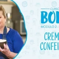 Imagem de uma mulher de avental jeans azul segurando um pote marrom com creme claro e os dizeres do curso ao lado direito