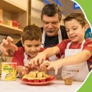 Imagem do Gentil e seus 2 netos Lucca e Davi com um prato de Bolinho de Chuva Assado e uma lata de Leite NINHO ao lado.