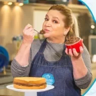 Imagem de uma mulher de avental jeans azul segurando um pote vermelho com creme marrom e os dizeres do curso ao lado direito