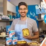 Montagem de um menino com avental azul e os dizeres do programa ao lado direito com a logomarca