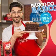 Montagem de um rapaz segurando um bolo em tom marrom ao lado dos dizeres com o nome do programa e os logos da marca