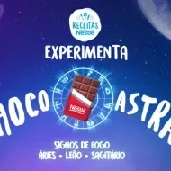 Imagem em tom roxo do céu com alguns planetas, uma barra de chocolate ao centro e um mulher com um braço levantado e dizeres