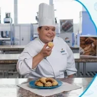 Montagem com a imagem de uma chefe com uniforme branco à esquerda e à direita o título da aula de broa de milho