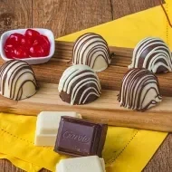 Montagem com a imagem das trufas à esquerda e ao lado o título da receita, com fundo chapado em amarelo e logos das marcas