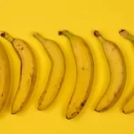 Bananas enfileiradas em cima de um pano amarelo 