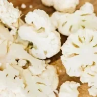 Couve Flor fatiadas em cima de uma tabua de madeira