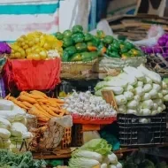 Várias cestas com vegetais dentro delas em uma banca