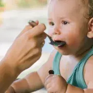 Mãe alimentando o seu filho bebê