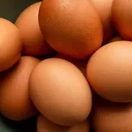 Pessoa com uma cesta de ovos na mão