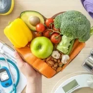 Cesta em formato de coração com alimentos saudáveis, entre itens fitness e médicos, representando diabetes.