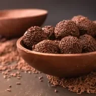 Ovo de chocolate aberto recheado com brigadeiros de chocolate com granulado.