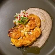 Bife de couve-flor marinado no missô, creme de cogumelos e castanha e vinagrete de talo de couve-flor.