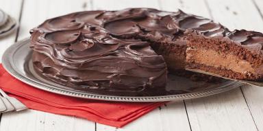 Recheio de chocolate para bolo Imagem de um bolo mousse de chocolate com uma fatia sendo retirada com uma espátula mostrando o recheio.