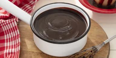 Cobertura de chocolate dentro de uma panela em cima de uma bancada