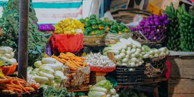 Várias cestas com vegetais dentro delas em uma banca