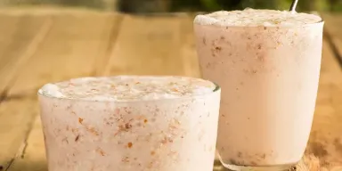 Frappé de Amêndoas com Coco em cima de uma mesa de madeira
