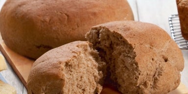 17 receitas de pão caseiro fofinho Imagem de um pão caseiro cortado ao meio.