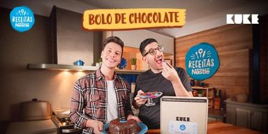Imagem de dois homens no centro atrás de uma bancada com receitas de bolo e brigadeiros e acima o título com logos das marcas