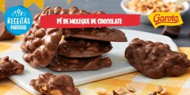Fotografia mostra um doce de amendoim coberto com chocolate espalhados pela mesa.