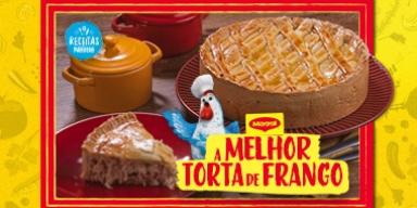 Fotografia mostra uma torta inteira de frango e uma galinha azul com chapéu de cozinheiro.
