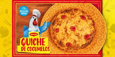 Fotografia mostra uma quiche gratinado e uma galinha azul com chapéu de cozinheiro.