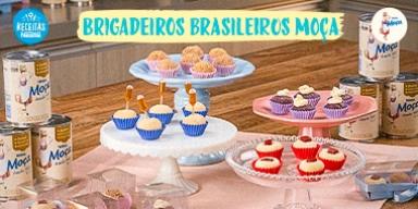 Fotografia mostra quatro tipos de brigadeiros dispostos sobre uma mesa de madeira.