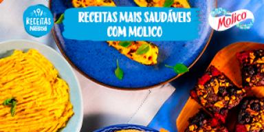 Fotografia de de três receitas, abobrinha recheada, hommus e brownie de frutas vermelhas vistas de cima sobre uma mesa de mad